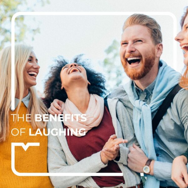 Four people laughing together in nature