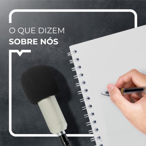 Microfone e uma mão a escrever num caderno