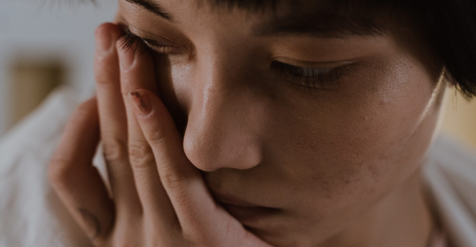 Femme qui tient sa tête dans ses mains en étant triste